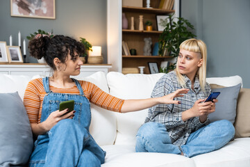 Young lesbian couple at home have a problem and argue due to jealousy caused by chatting and...