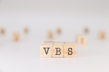 VBS letters. Concept of Vacation Bible School written on wooden cubes isolated on white background.