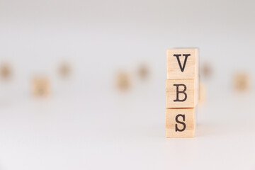 VBS letters. Concept of Vacation Bible School written on wooden cubes isolated on white background.