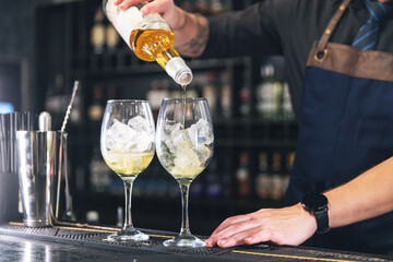 Bartender pours ingredients into glasses