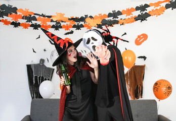 Couple make scary gestures on the night of Halloween celebrations, wearing dressed carnival...