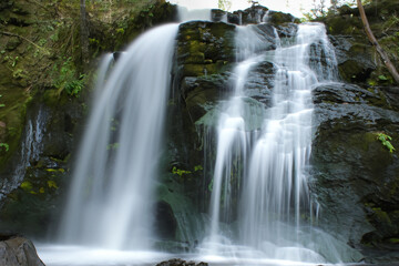 Waterfall. Majestic waterfall. Panoramic beautiful deep forest waterfall. Fantasy landscape with waterfalls, panorama. Waterfall in the forest