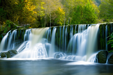 Waterfall. Majestic waterfall. Panoramic beautiful deep forest waterfall. Fantasy landscape with waterfalls, panorama. Waterfall in the forest