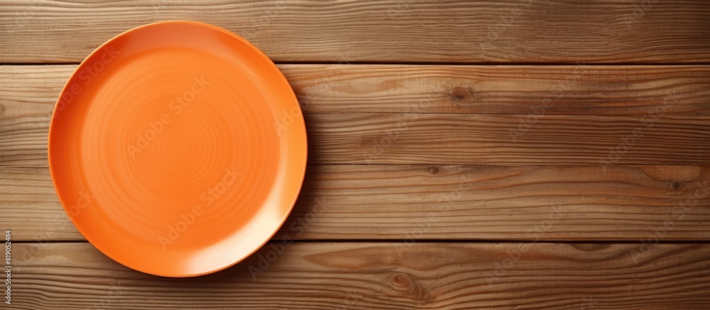 Aufkleber Top view of empty orange plate on wooden background Empty space for your design. copy space available