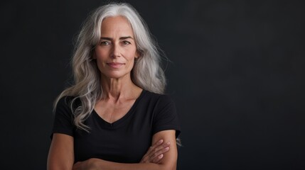 Mid age woman standing behind a flat background