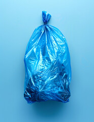 Fototapeta premium Blue plastic garbage bag lies on blue background.