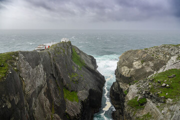 Person Standing on Cliff Overlooking the Ocean