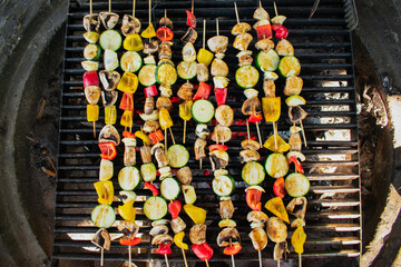Colorful vegan or vegetarian barbecue consisiting of mushrooms, bell peppers, zucchinis and onioins