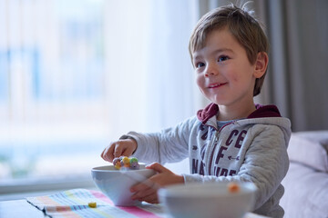 Cereal, smile and child in home with breakfast for health, growth or development for kid in...