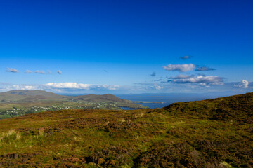 Grassy Hill Overlooking Distant Body of Water
