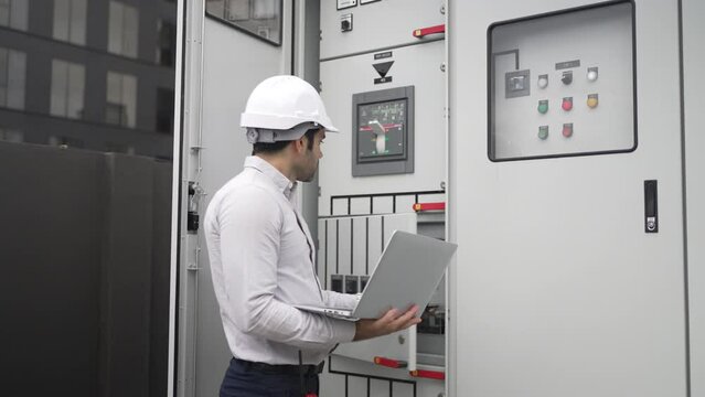 Engineer is working on the rooftop of high rise building.