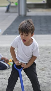Playground Thrill - Young Boy Charges With Toy Shovel In Sand, Running Towards the Camera
