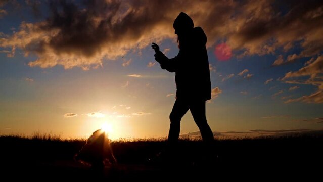 JOVEN JUGANDO CON PERRO AL ATARDECER EN CAMPO