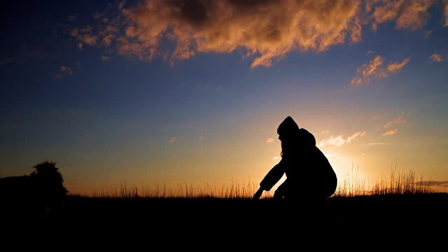 JOVEN JUGANDO CON PERRO AL ATARDECER EN CAMPO
