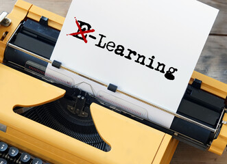 Yellow typewriter on a desk with paper showing Learning instead of e-learning