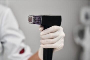 A woman receives Rf-lifting in a beauty salon.
