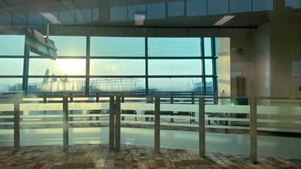 Morning sunshine reflections in the window of waiting gate room in Airport 