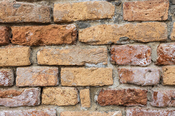 Close up of an old weather wall of bricks with heavy texture.