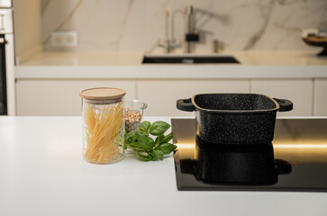 Black marble square pot on induction hob with food