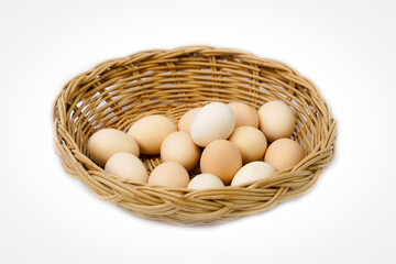 Organic chicken eggs in a bamboo basket on a white background are eggs that come from chickens raised on organic food. They do not contain toxic residues that are harmful to the body.