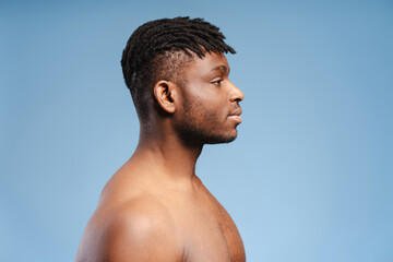 Side view, pensive african american man, fashion model with bare torso looking away at copy space