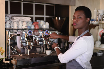 Focused female barista operates a professional espresso machine in a cafe setting