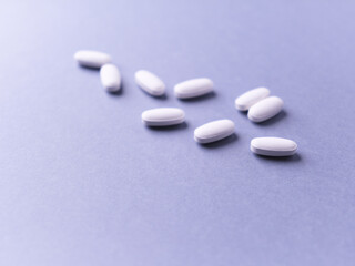 Amino acids tablets. Nutrition for bodybuilding. Fitness supplements on bright paper background. Soft focus. Copy space.	