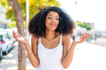 Young African American woman at outdoors With glasses and having doubts