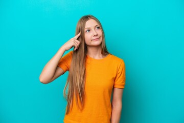 Young Russian woman isolated on blue background making the gesture of madness putting finger on the head