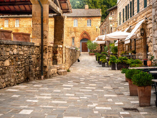 Obraz premium Dawn has just dawned over an ancient medieval village in Tuscany, with stone houses, a black cat, no people
