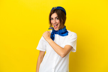 Airplane stewardess woman isolated on yellow background celebrating a victory