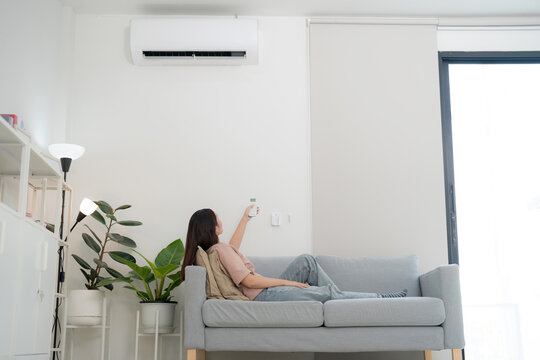 Young woman enjoying air conditioning at home