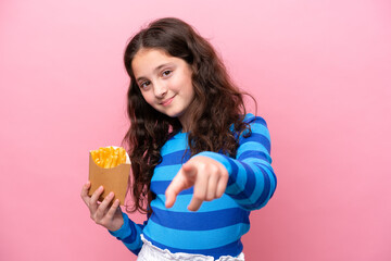 Little caucasian girl celebrating a birthday isolated on white background points finger at you with a confident expression