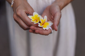 girl and flower. a young girl holds a white flower in her palm. A model poses with a flower in her...