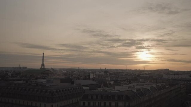 A stunning March sunset in Paris from the rooftop of Galeries Lafayette Haussmann, with the iconic Eiffel Tower towering among the city buildings.