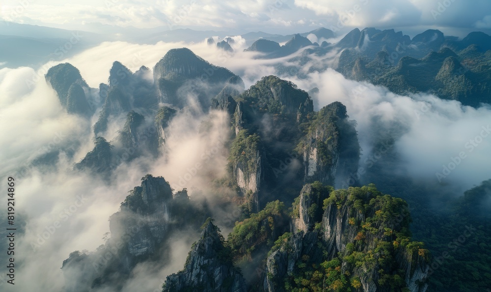 Wall mural aerial view of rocky cliffs covered by the clouds. 