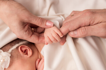 The palm of a newborn in parental hands. Palm of mom and dad. White background.
