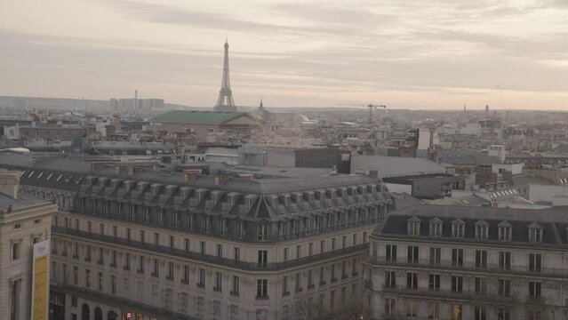 A stunning March sunset in Paris from the rooftop of Galeries Lafayette Haussmann, with the iconic Eiffel Tower towering among the city buildings.