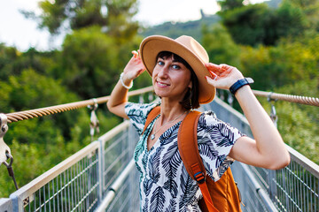 happy girl travels. young woman in a hat and with a backpack enjoys traveling.