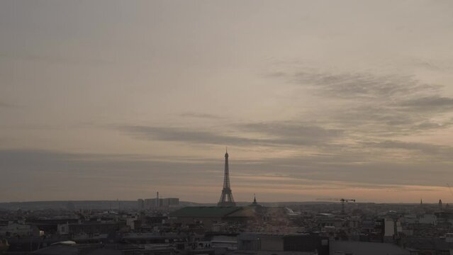 A stunning March sunset in Paris from the rooftop of Galeries Lafayette Haussmann, with the iconic Eiffel Tower towering among the city buildings.
