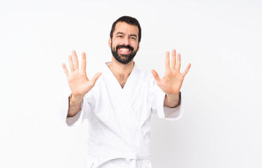 Young man doing karate over isolated white background counting ten with fingers