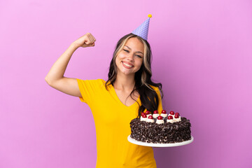 Teenager Russian girl holding birthday cake isolated on purple background doing strong gesture