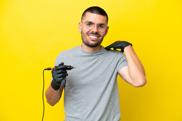 Tattoo artist caucasian man isolated on yellow background laughing