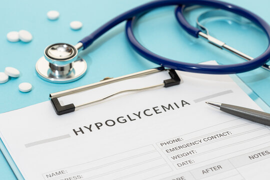 Hypoglycemia concept. Form, pills and and stethoscope on blue background