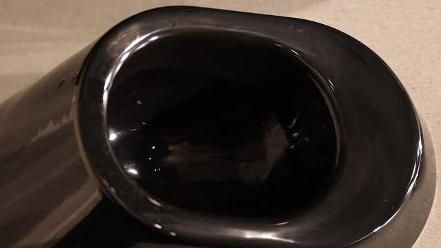Modern black urinal in a public toilet. Clean black toilet-urinals in a modern building with interior lighting. Modern black urinal with touch toilet in public men's restroom