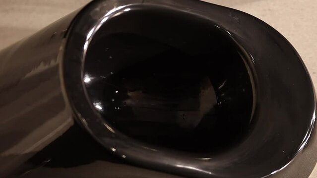 Modern black urinal in a public toilet. Clean black toilet-urinals in a modern building with interior lighting. Modern black urinal with touch toilet in public men's restroom