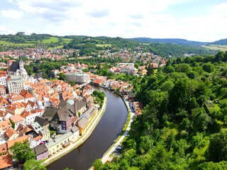 Panorama of Cesky Krumlov, Czech Republic. Red roofs and old medieval houses, water of Vltava River. A beautiful Czech city. View from drone, Krumlov