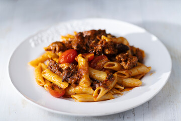 italian penne pasta in oxtail bolognese sauce