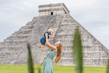 Beautiful tourist woman and her son baby observing the old pyramid and temple of the castle of the...