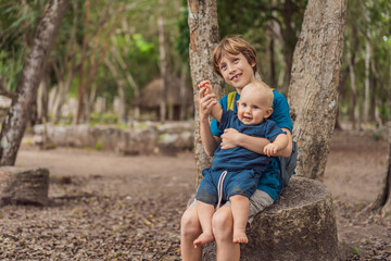 Fototapeta premium Happy laughing teen boy holding his baby brother